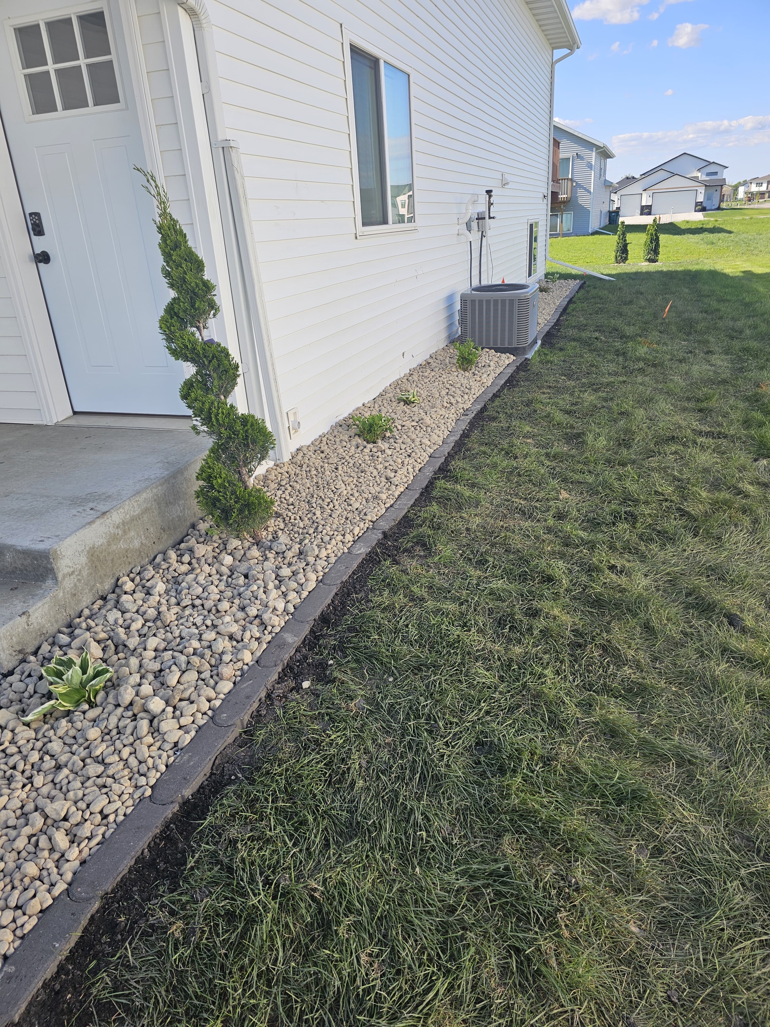 PK Landscaping completed rock edging and spiral bush installation in Fargo ND